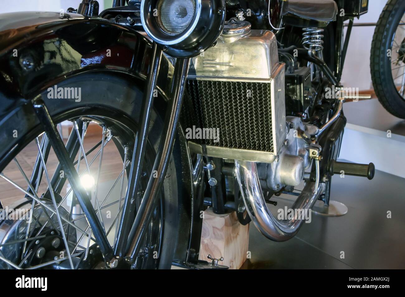 The detail of the old motorcycle with part of the frame, engine, fuel tank, fuel lead and cooler. Stock Photo