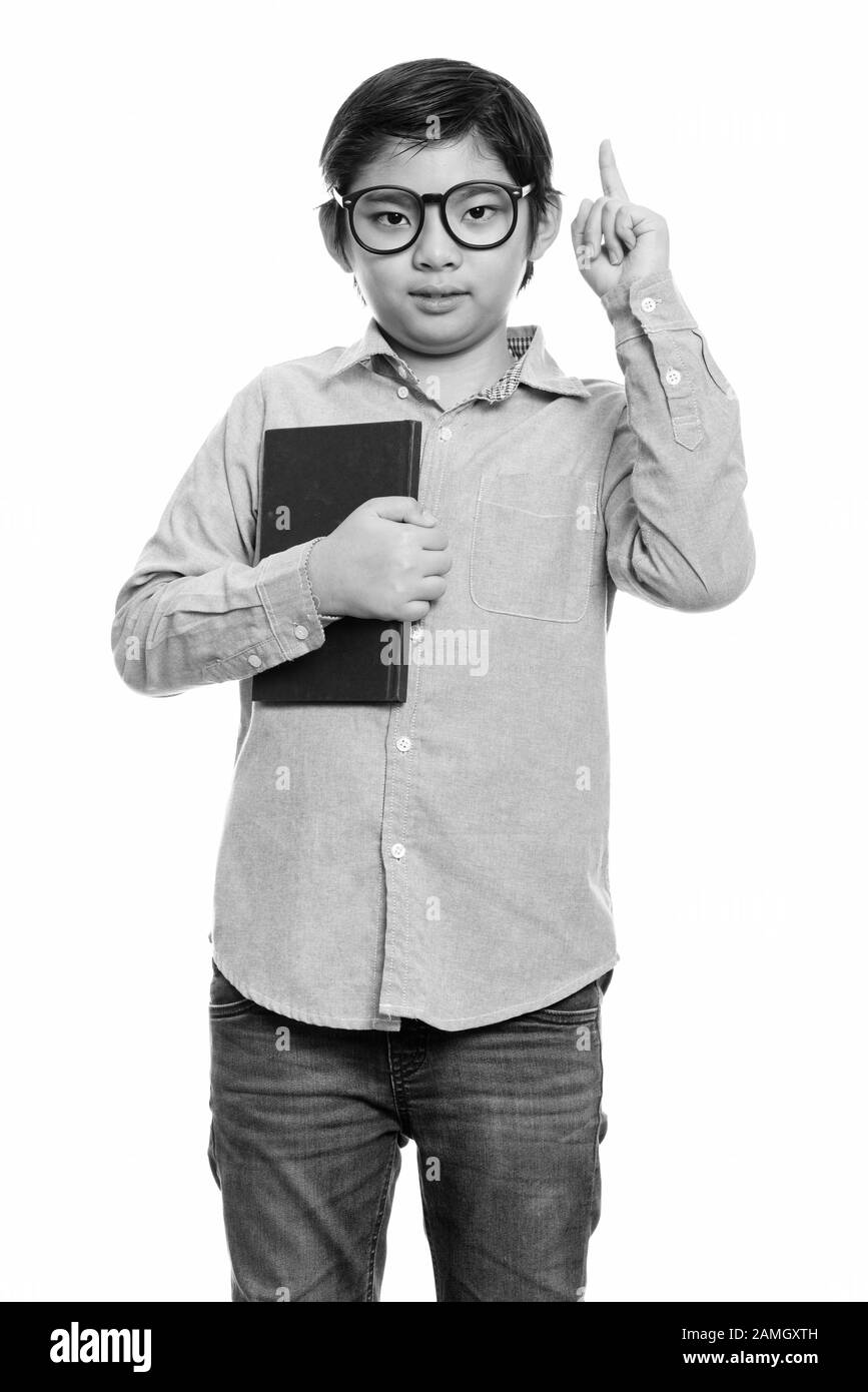 Studio Shot Of Cute Japanese Boy Holding Book And Pointing Finger Up Stock Photo Alamy