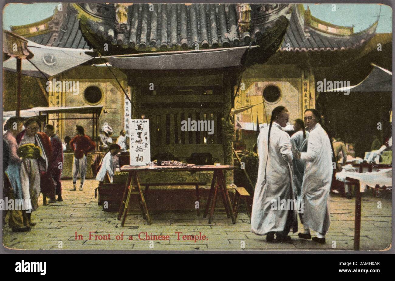 Illustrated postcard of a group of men wearing traditional robes and queue hairstyles in front of a Chinese temple, published by Chrom, 1915. From the New York Public Library. () Stock Photo
