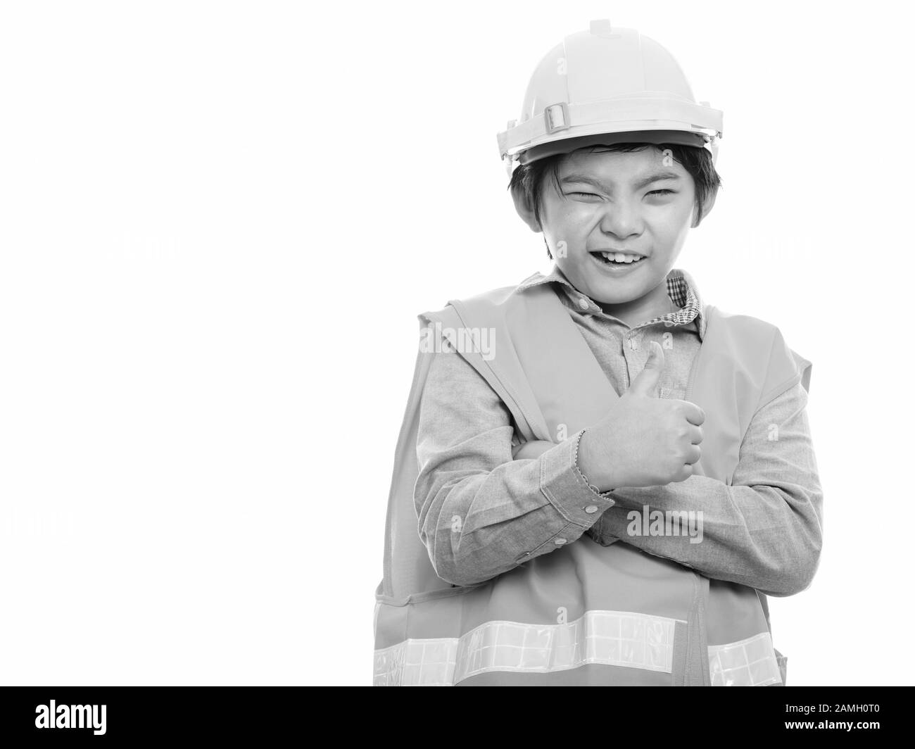 Happy Japanese boy construction worker smiling and winking while giving thumb up Stock Photo