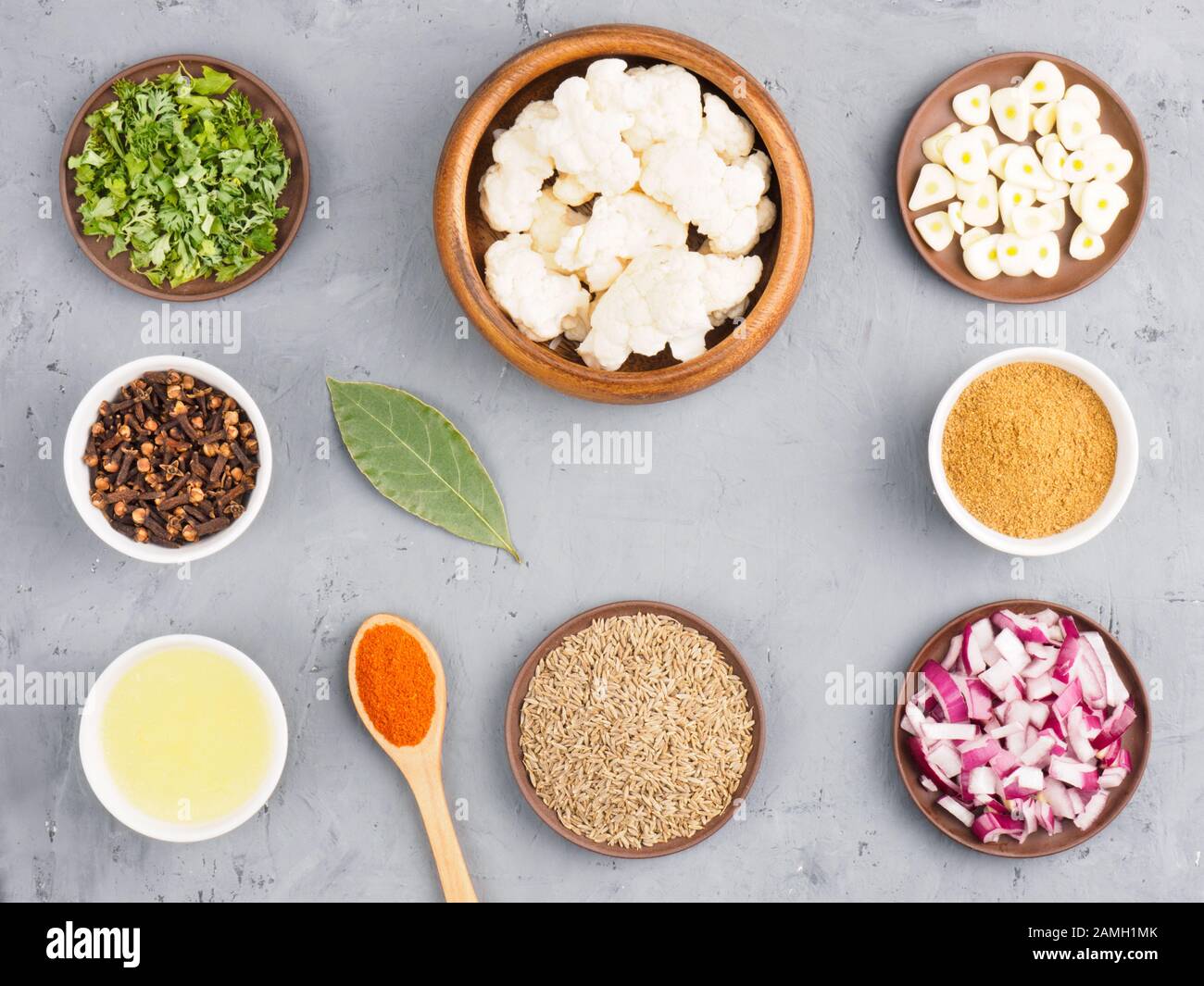 Ingredients for cooking cauliflower butter, onion, cumin (jeera), red chili pepper, masala, bay