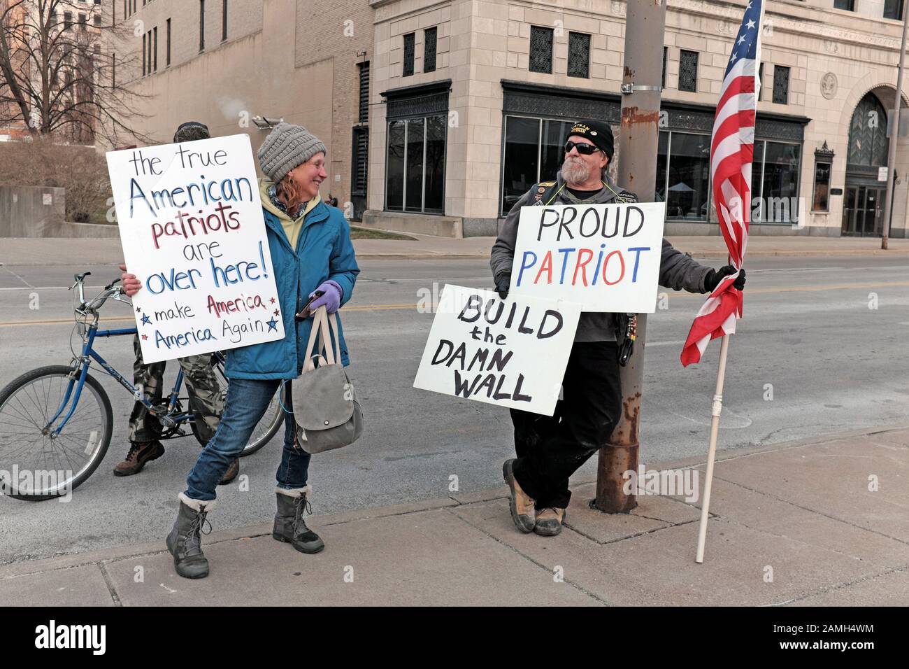 US patriots from both political sides stand side by side with the US flag on a street in Toledo, Ohio during the 2020 Trump re-election campaign visit. Stock Photo