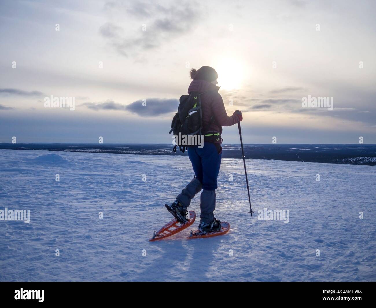 Snowshoeing woman trekking in winter mountains (copy space Stock