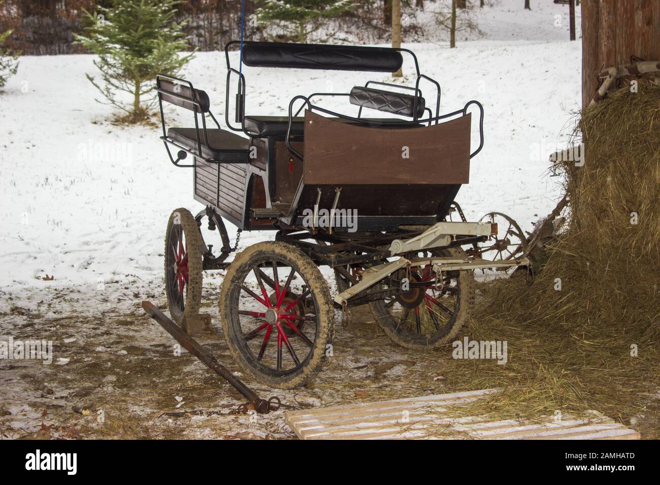 An old carriage that binds to a horse.  The carriage and hay for horse in winter Stock Photo