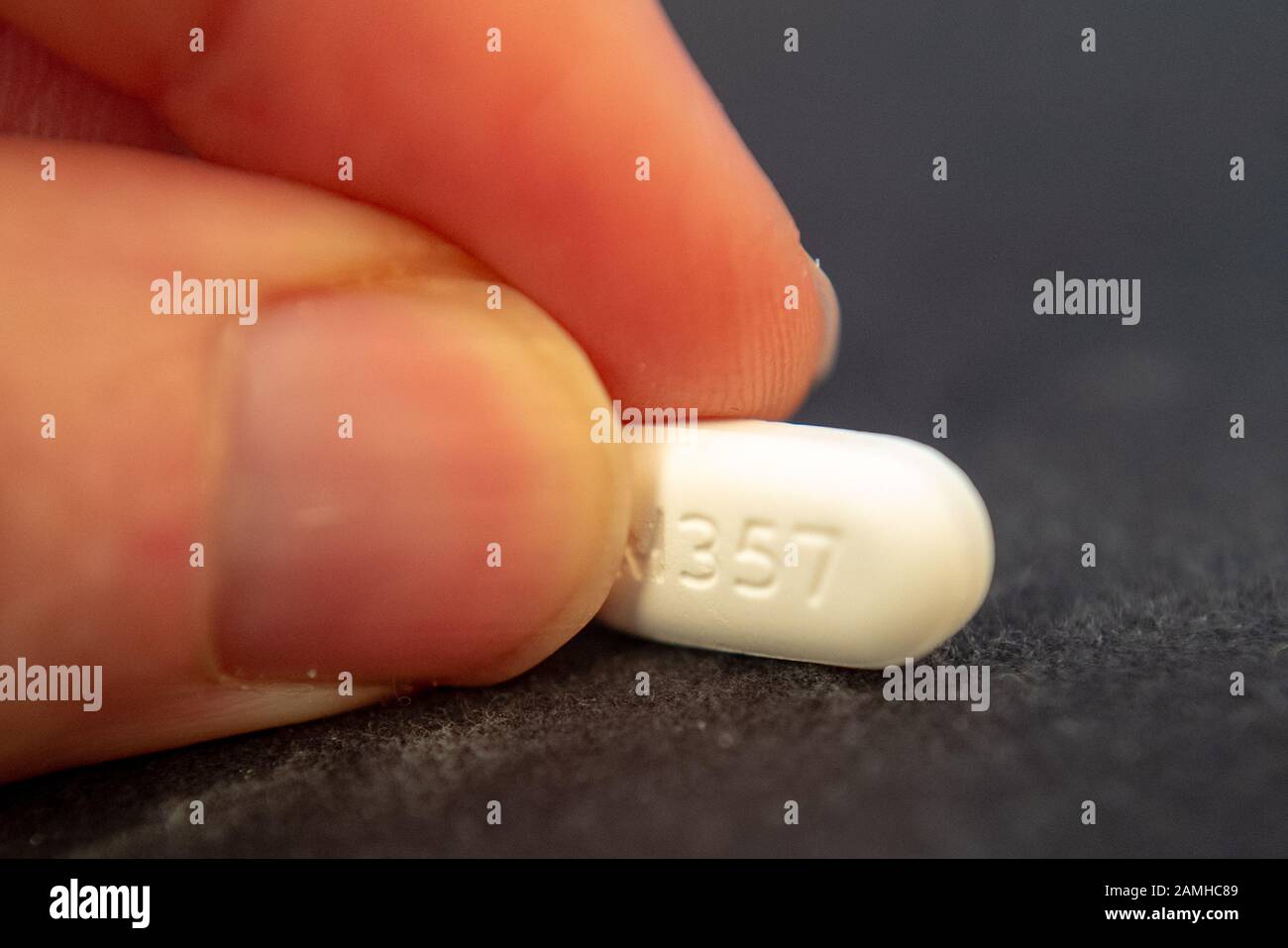 Illustrative image, close-up of hand of a man holding a pill of the combination narcotic opioid pain medication hydrocodone 5-acetaminophen 500, marketed under the trade names Vicodin or Lortab, San Ramon, California, December 10, 2019. Many regulators and lawmakers are focusing on the opioid crisis in the United States, which has led to addiction and illegal drug use. () Stock Photo