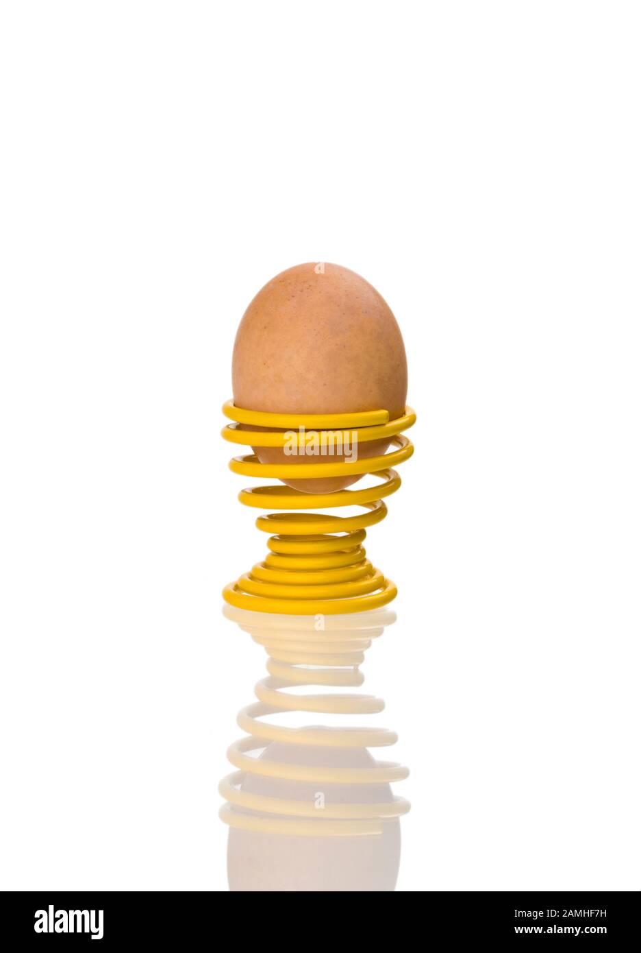 Brown egg in a yellow spring-type egg cup Stock Photo