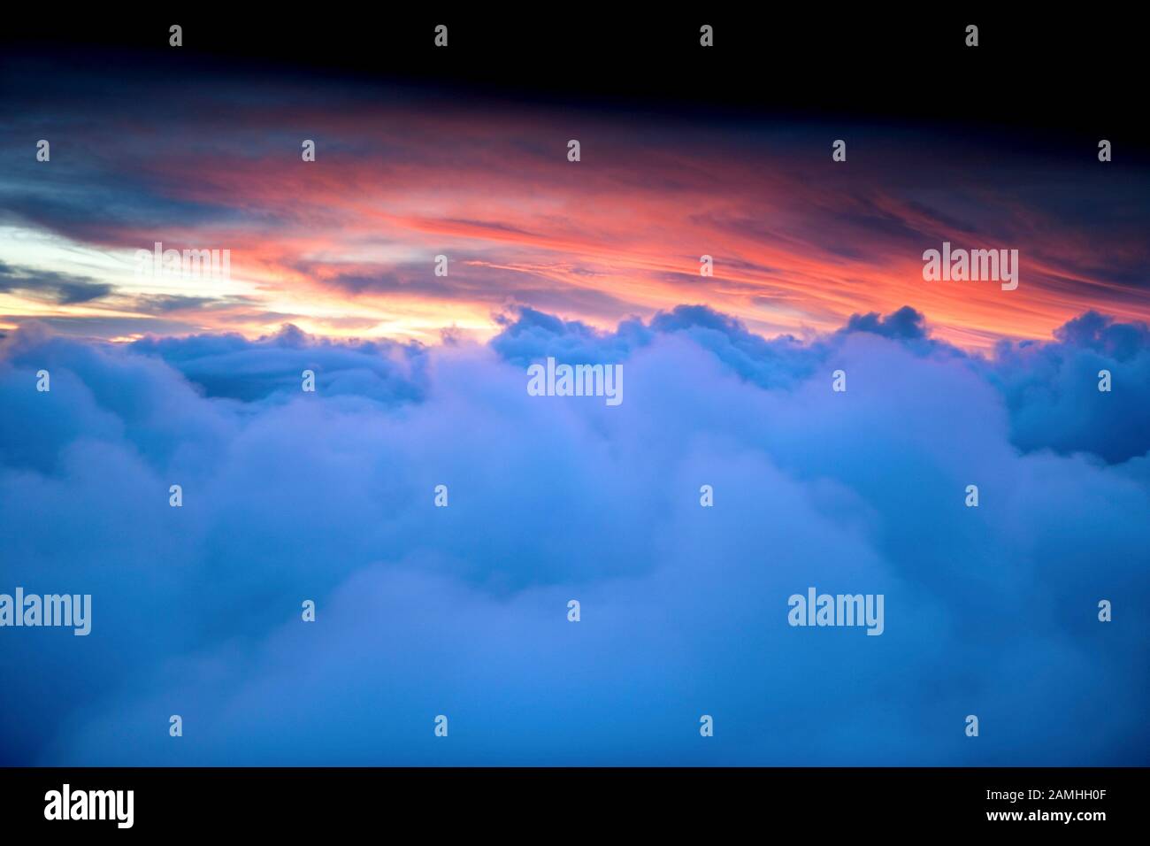 View of clouds and sunset close up perspective while flying in an airplane aeroplane Stock Photo