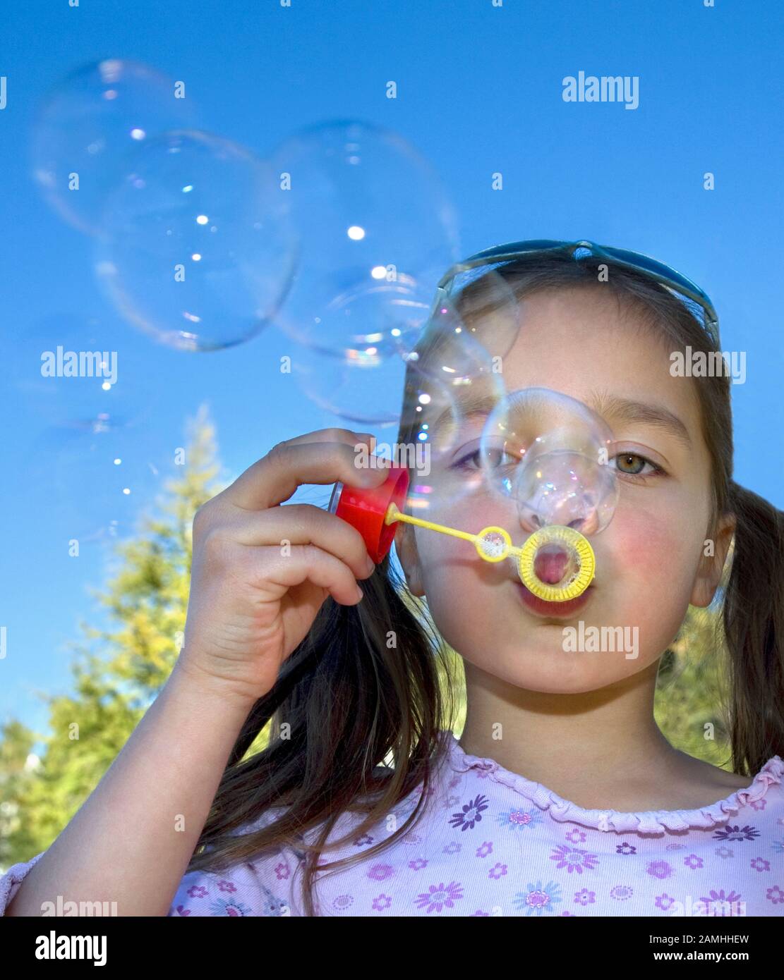 Young Girl with pigtails Blowing Bubbles Stock Photo - Alamy