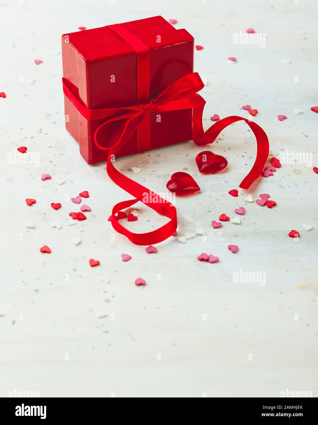 Gift red box with red bow ribbon and hearts on light background for ...