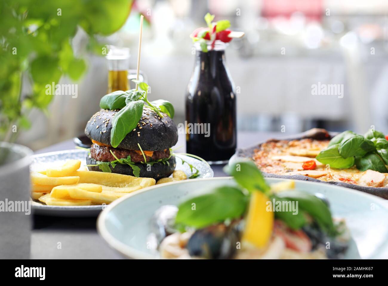 Black food. Burger, pizza, pasta, dishes with activated charcoal. Stock Photo