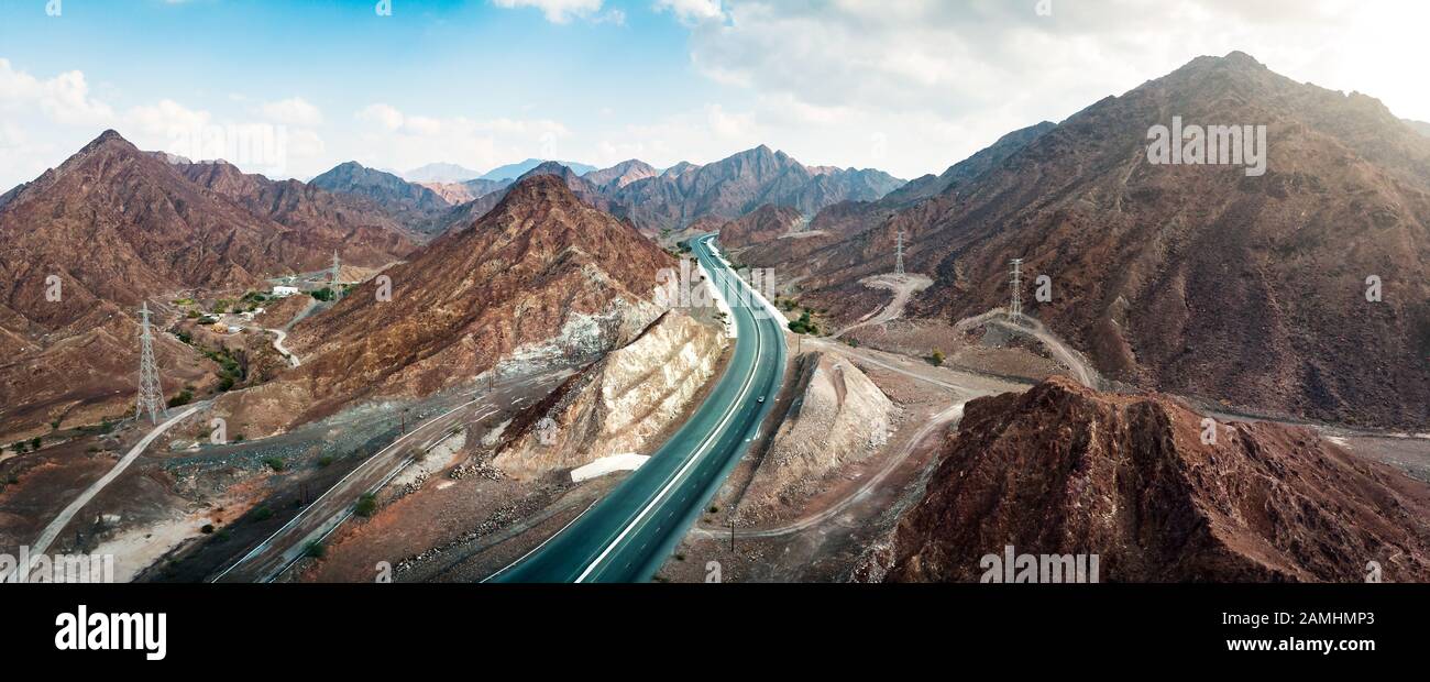 Scenic road through Hajar mountain range stretching through UAE and Oman aerial view Stock Photo