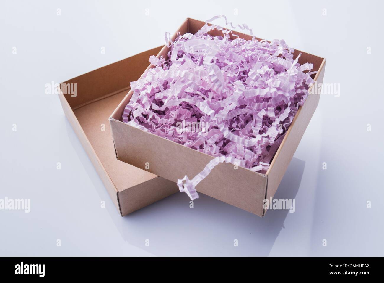 Opened two-piece box stuffed with colorful shredded paper. Stock Photo