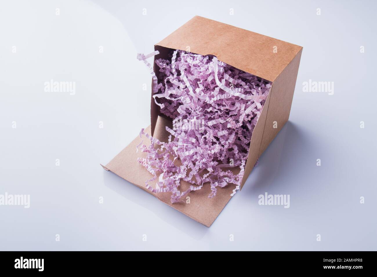 Purple pink shredded paper gifting stuffing cardboard box Stock Photo