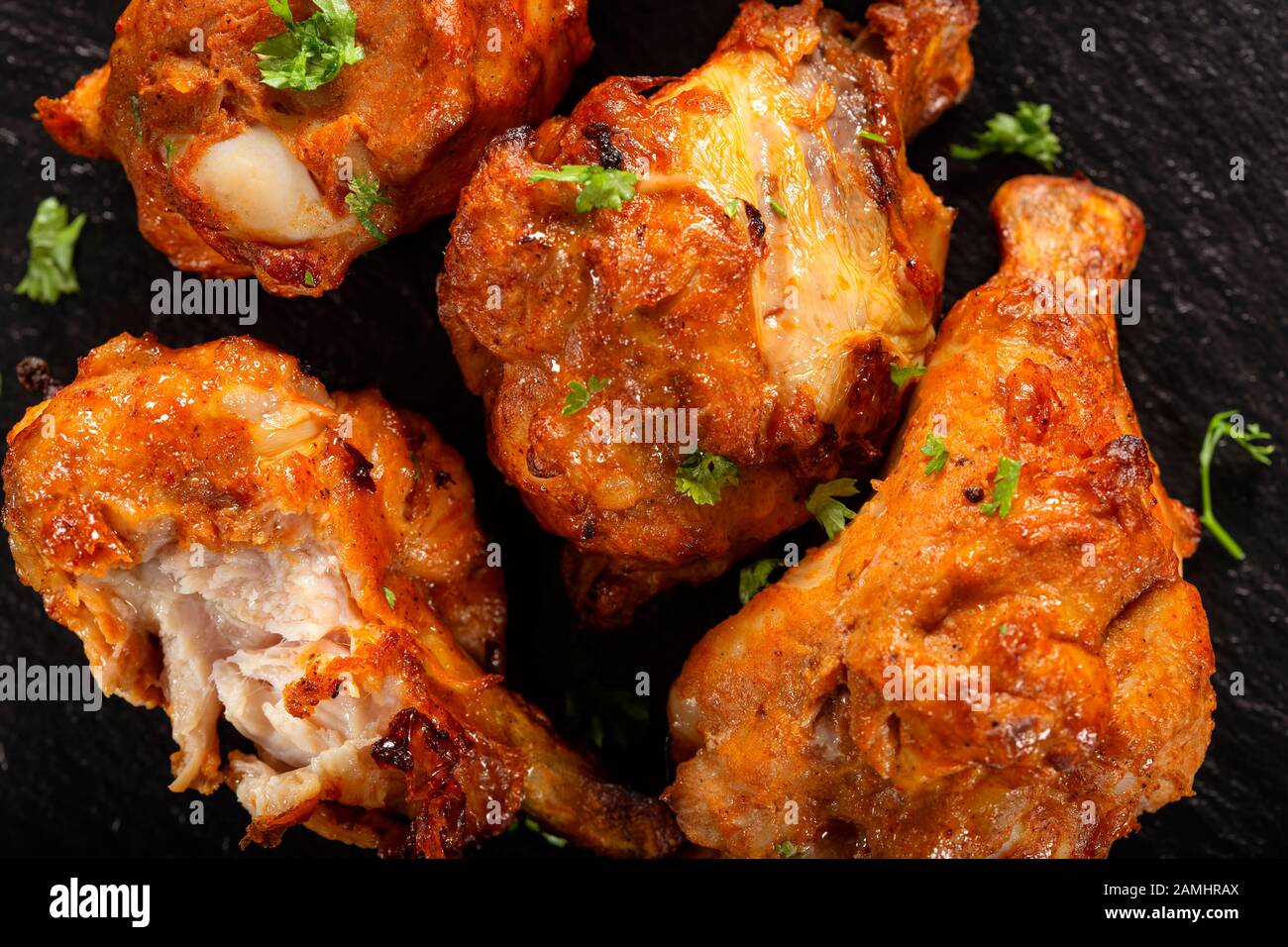 Roasted chicken drumstick on dark slate - top view Stock Photo