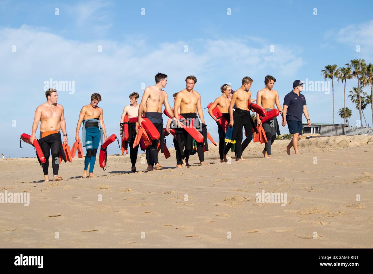 Group of bare chested Junior Life Guards walking on beach Corona del Mar State Beach Newport Beach Southern California USA Stock Photo