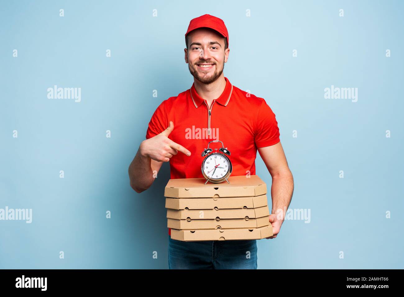 Deliveryman is punctual to deliver quickly pizzas. Cyan background Stock Photo