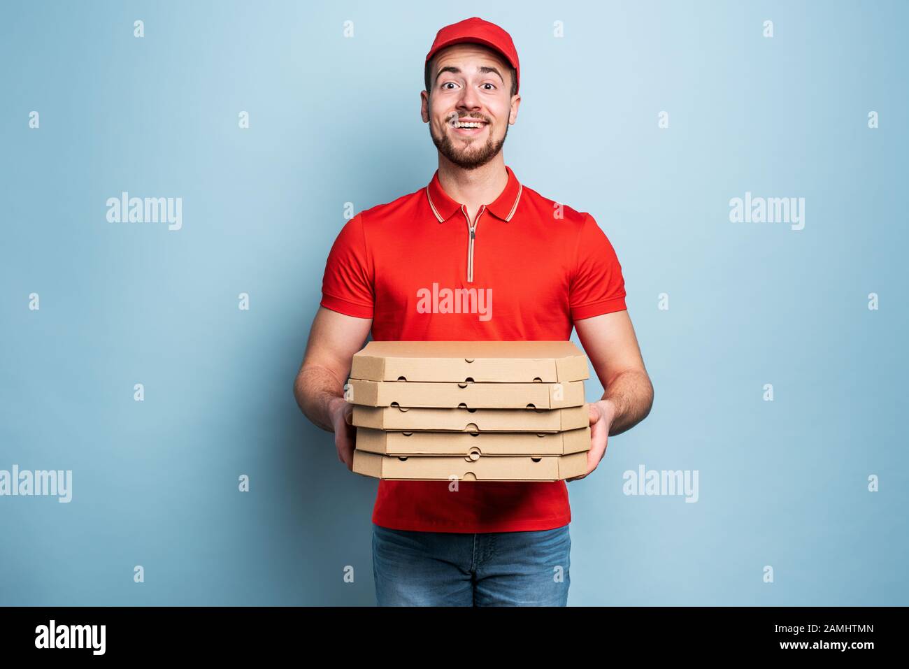 Happy deliveryman happy to delivers pizza with success. Cyan background Stock Photo