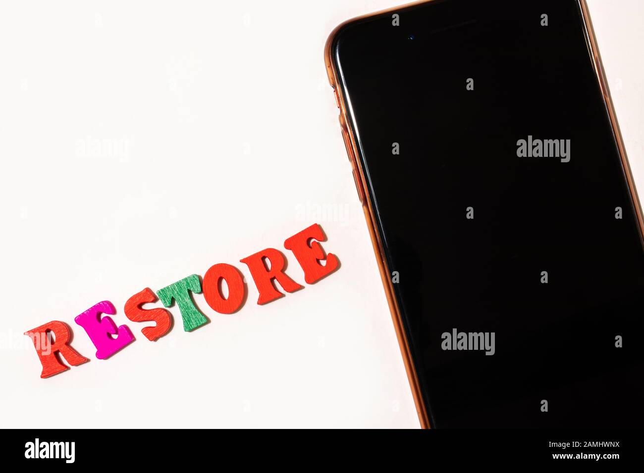 Phone with word restore on white background flat lay Stock Photo