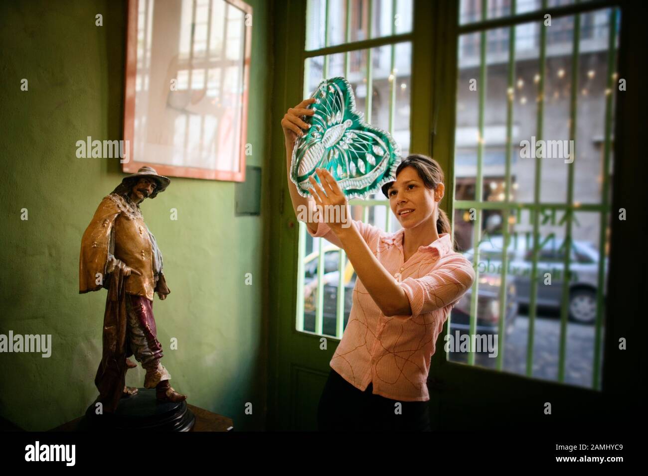 A woman thoughtfully looks at a decorative piece. Stock Photo