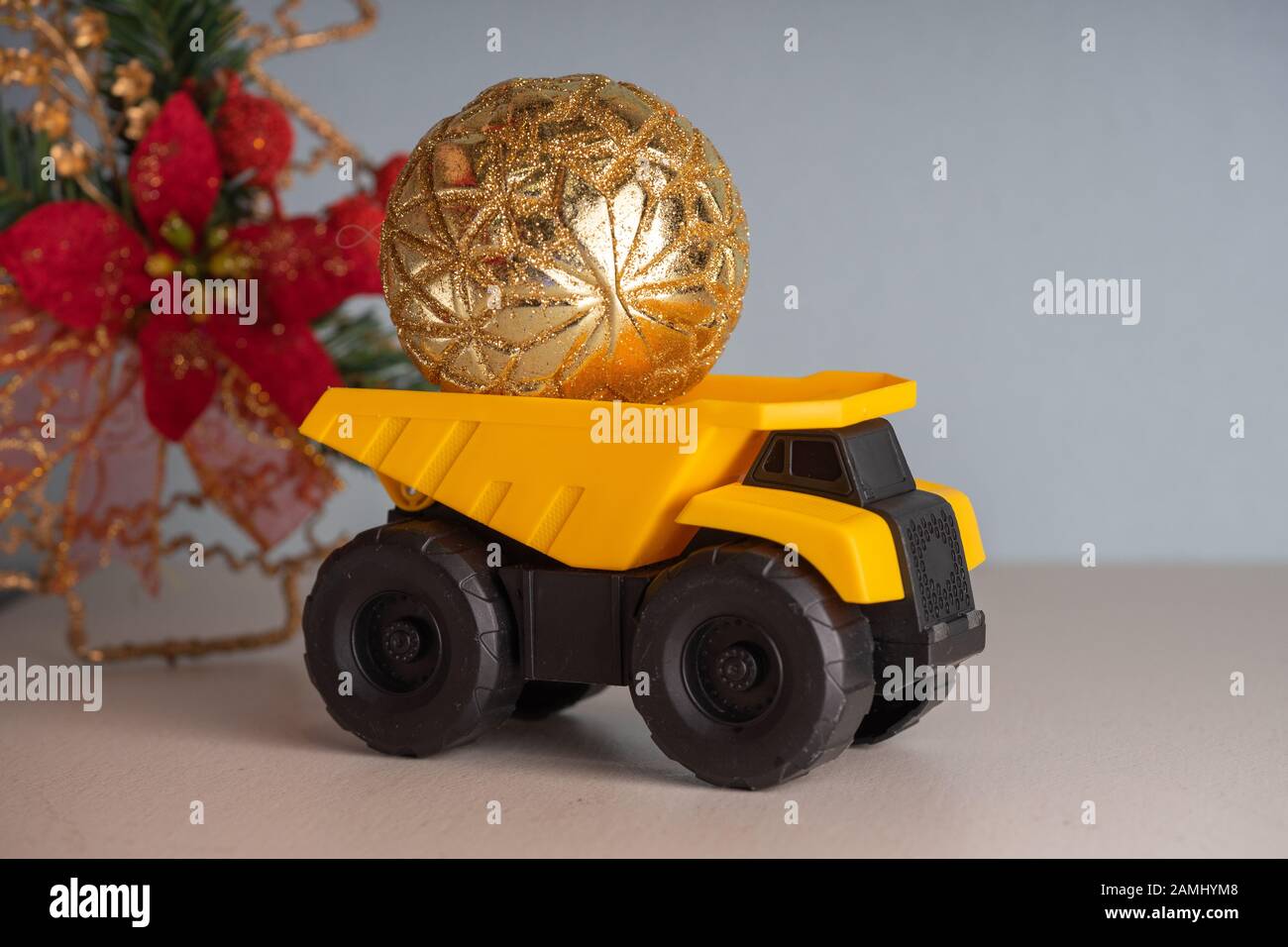 Yellow dump truck model with Christmas tree toy. Garland lights in