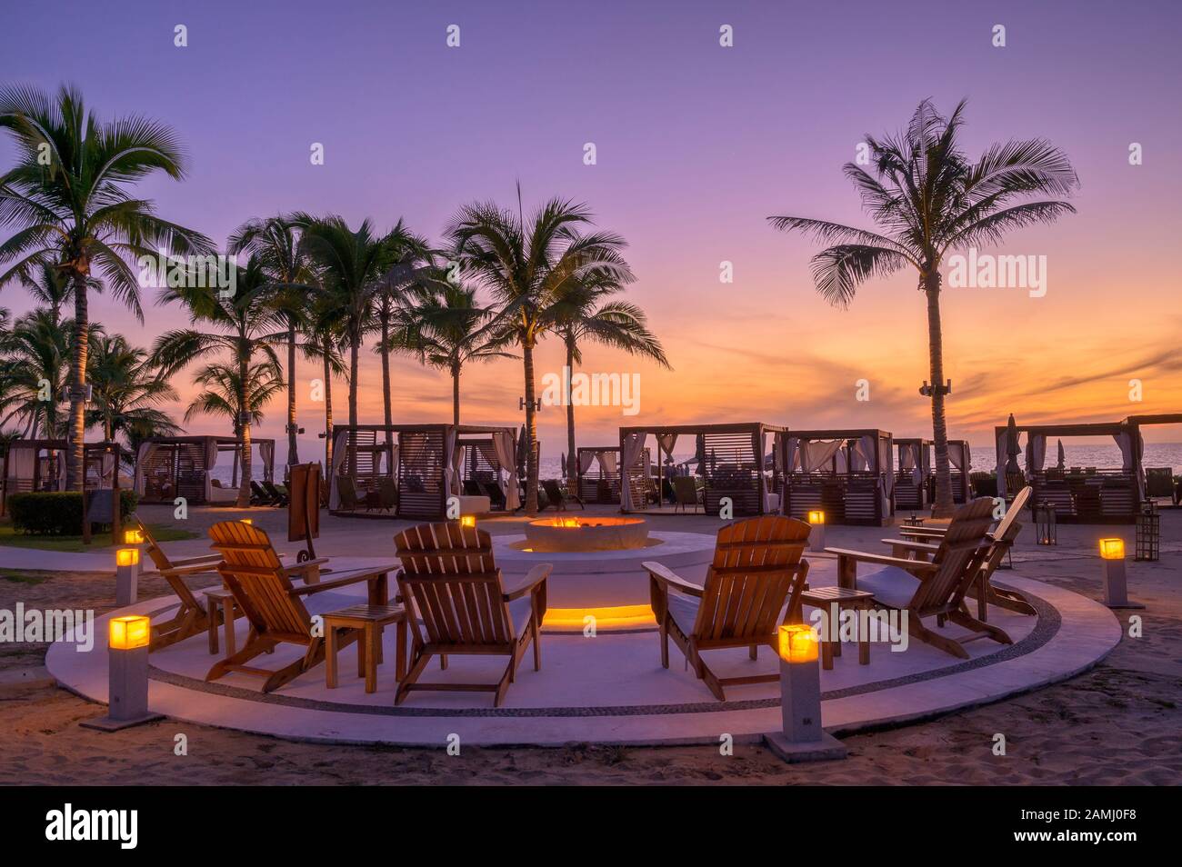 Sunset around the beachside fire pit at Marival Resort's Mozzamare Beach Club in Nuevo Vallarta, Riviera Nayarit, Mexico. Stock Photo