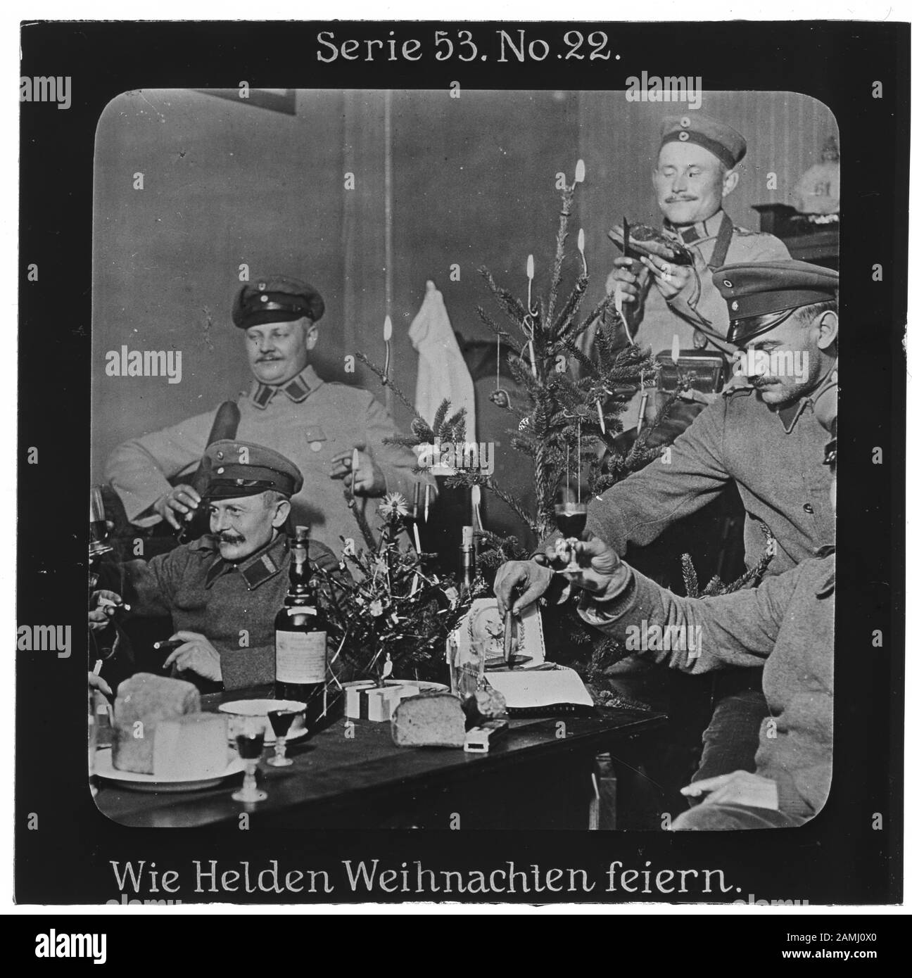 Projection für Alle: Weltkrieg Serie 53 Kolonial-, See- und Landkämpfe No. 22. Wie Helden Weihnachten feiern. - Die Firma „Projection für Alle“ wurde 1905 von Max Skladanowsky (1861-1939) gegründet. Sie produzierte bis 1928 fast 100 Serien zu je 24 Glasdias im Format 8,3 x 8,3 cm im sog. Bromsilber-Gelatine-Trockenplatten Verfahren. Die Serien umfassten vor allem Städte, Länder, Landschaften aber auch Märchen und Sagen, das Alte Testament und den Ersten Weltkrieg. Stock Photo