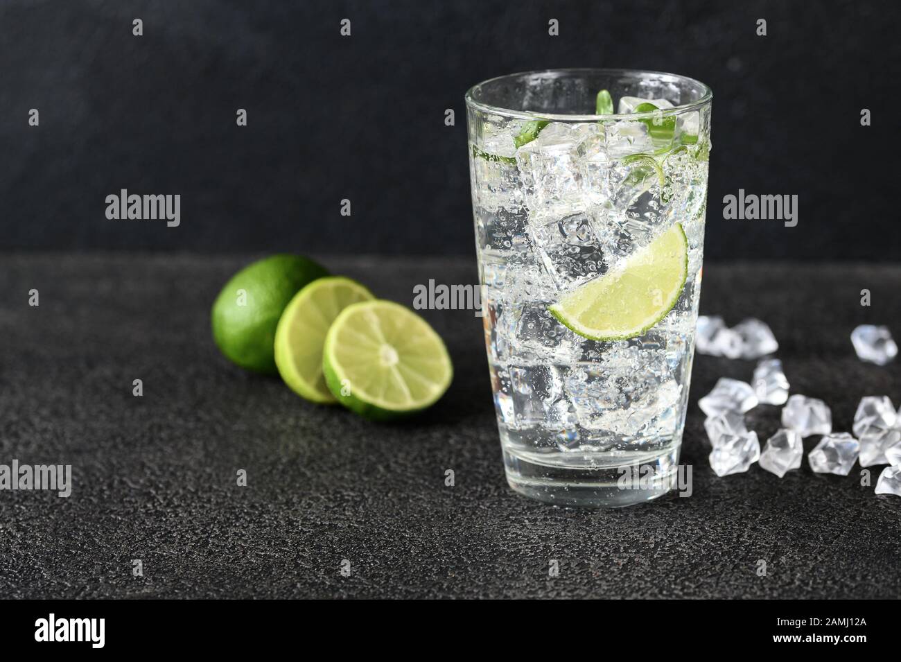 Glass of sparkling water with ice cubes and slice of lime Stock Photo ...