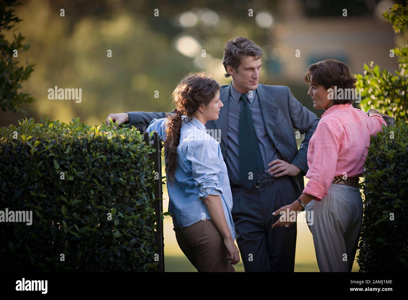 View of two women talking to a man Stock Photo - Alamy
