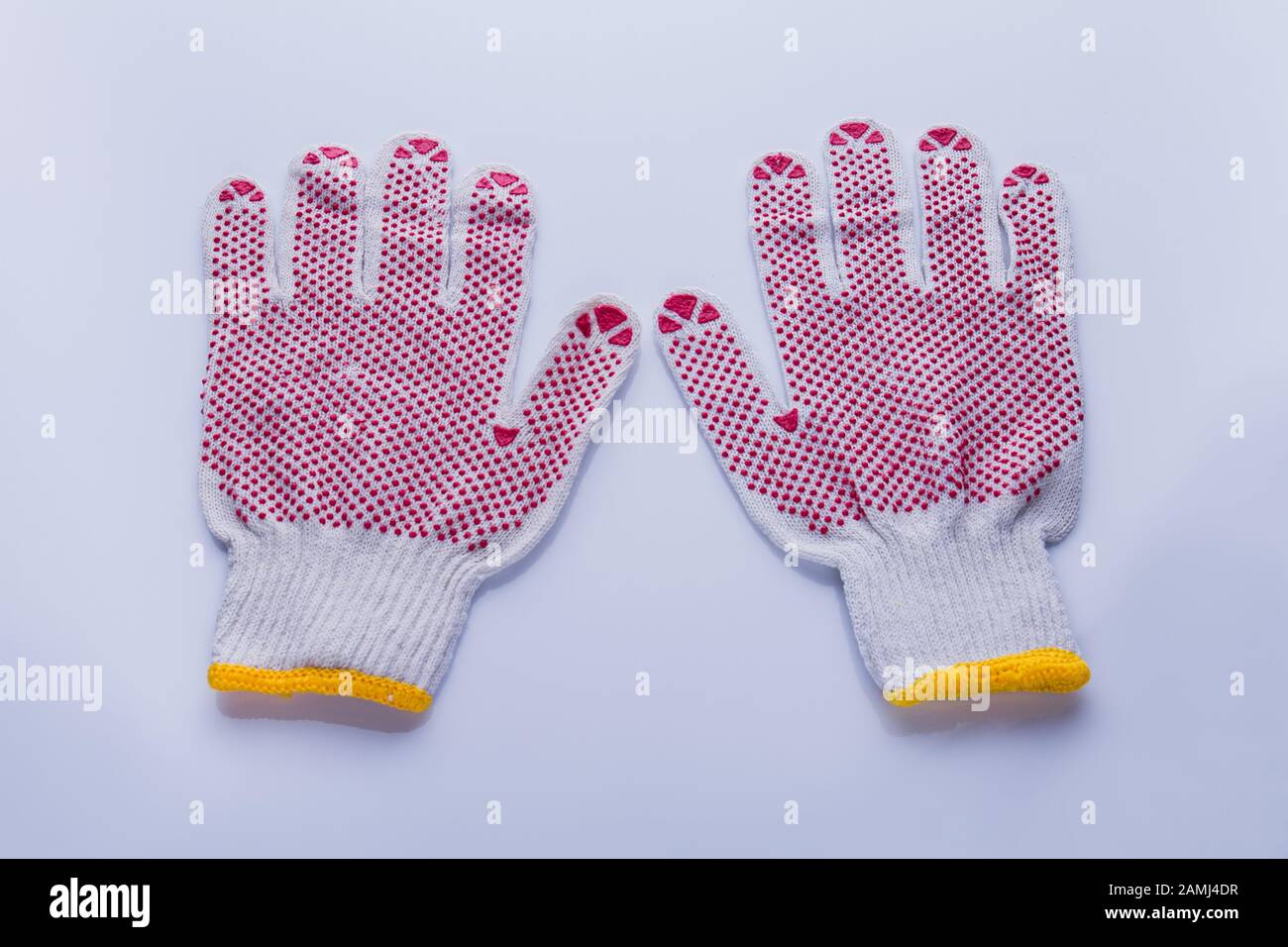 https://c8.alamy.com/comp/2AMJ4DR/pair-of-protective-working-cotton-gloves-with-red-rubber-dots-2AMJ4DR.jpg