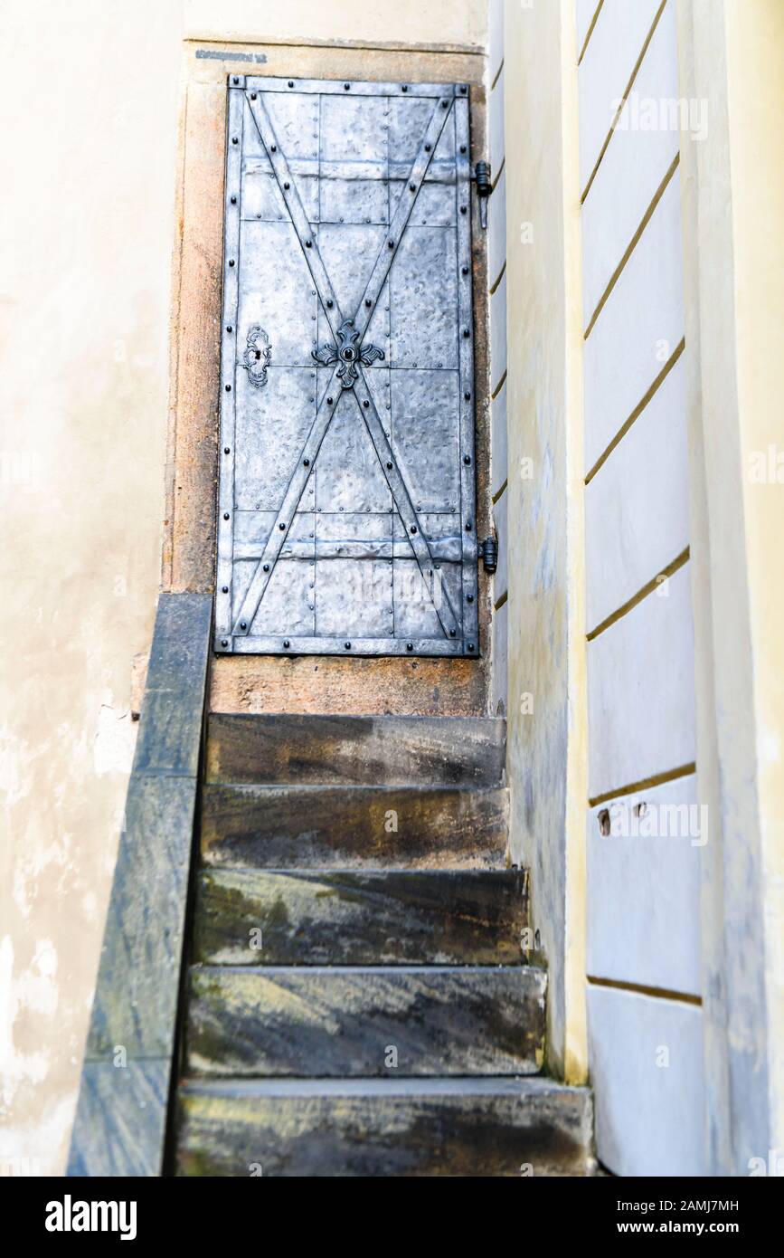 Steps leading up to an old, secure, iron door at a European Castle Stock Photo