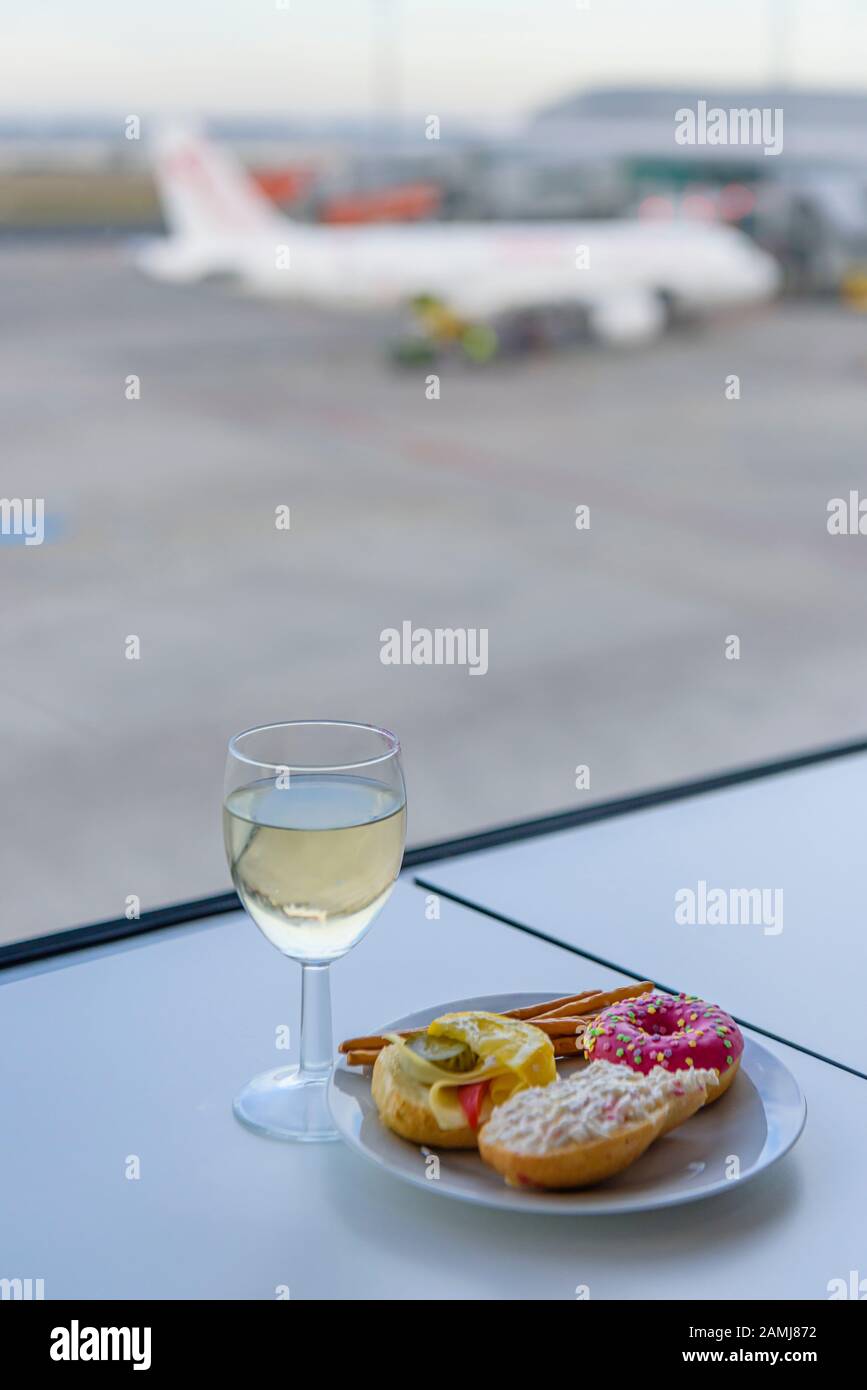 A glass of wine and some food in an airport business lounge Stock Photo