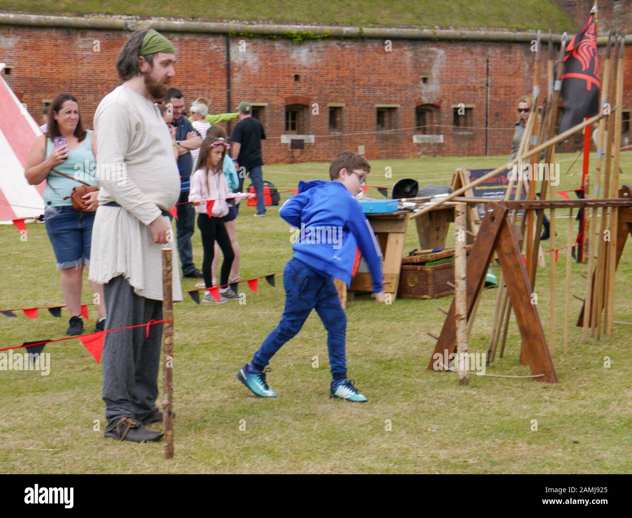 A young boy learning to throw a spear at a living history event. Stock Photo