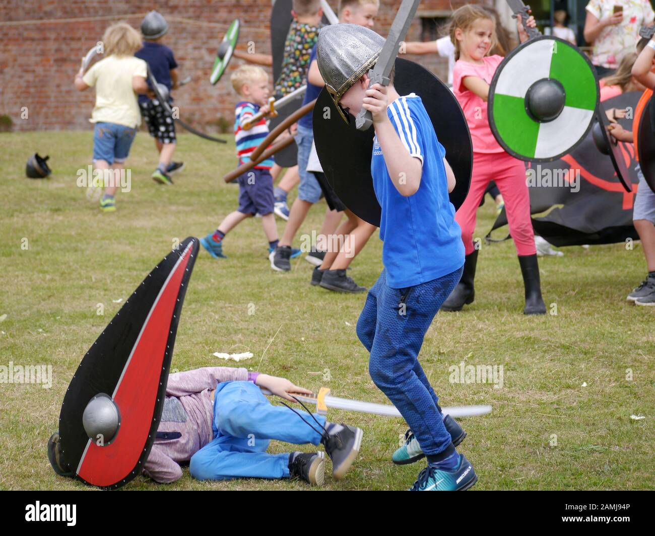 Children re-enacting a battle between Vikings and Saxons at an educational living history event Stock Photo
