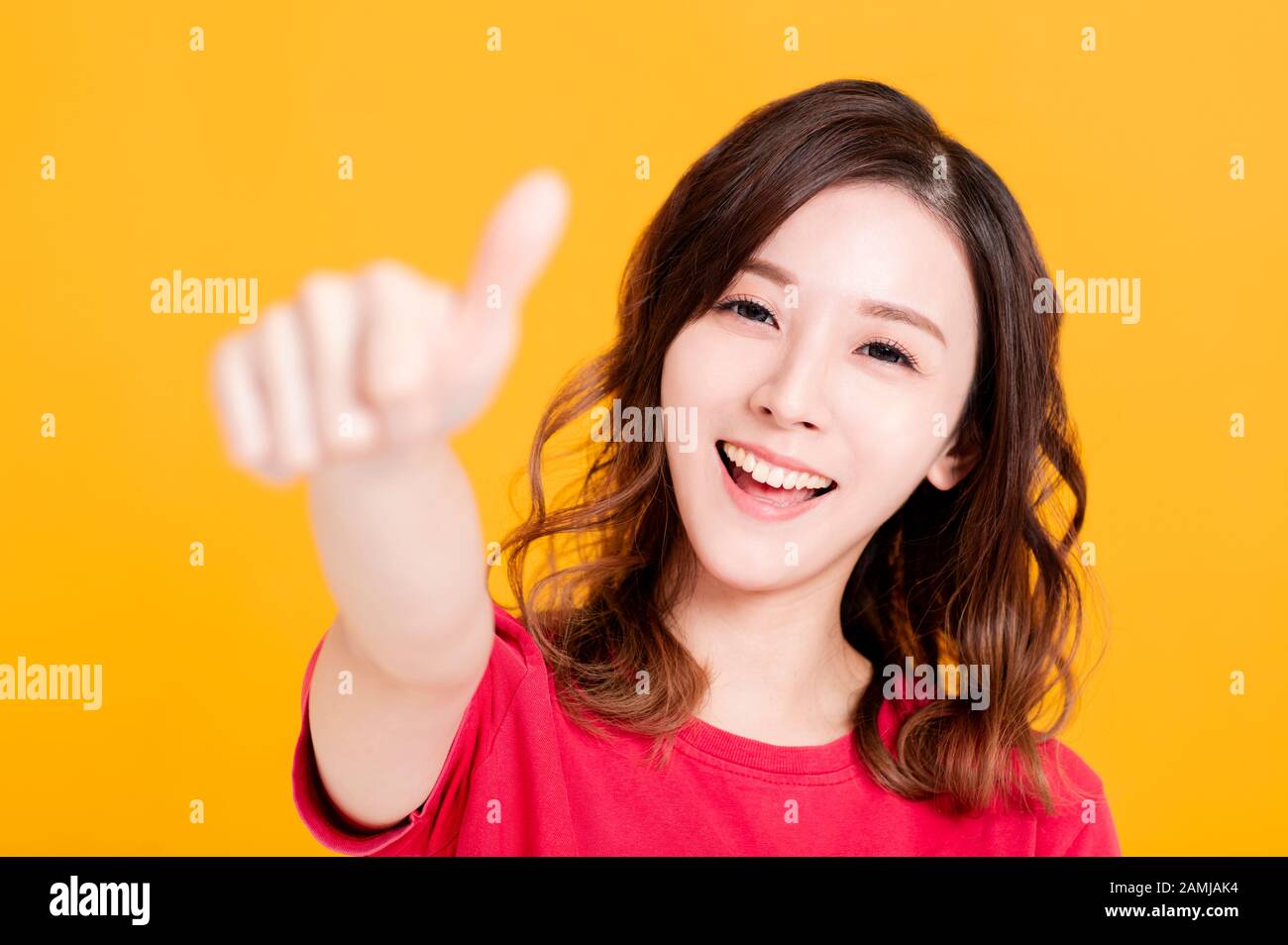 Closeup of Smiling Woman Making thumbs up  Gesture Stock Photo