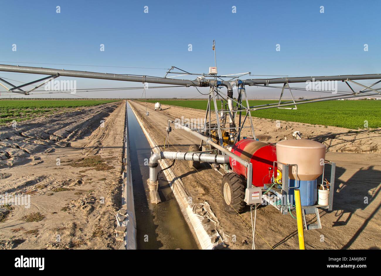 Self Propelled Linear Irrigation System operating, maturing carrot & potato fields. Stock Photo