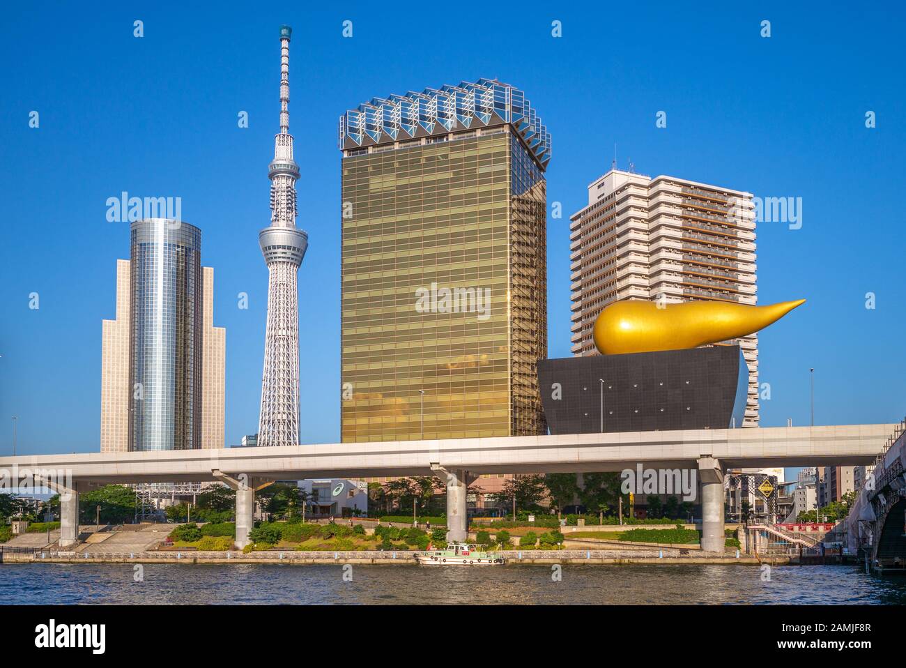 Tokyo, Japan - June 13, 2019: Asahi Beer Hall, designed by French designer Philippe Starck and was completed in 1989, on bank of Sumida River with tok Stock Photo