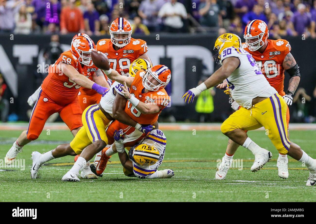 New Orleans, LA, USA. 13th Jan, 2020. Clemson quarterback Trevor Lawrence (16) shuffles a ball to a receiver as he is tackled by LSU defenders K'Lavon Chaisson (18) and Damone Clark (35) during the College Football National Championship between the Clemson Tigers and the LSU Tigers at the Mercedes Benz Superdome in New Orleans, LA. Jonathan Mailhes/CSM/Alamy Live News Stock Photo