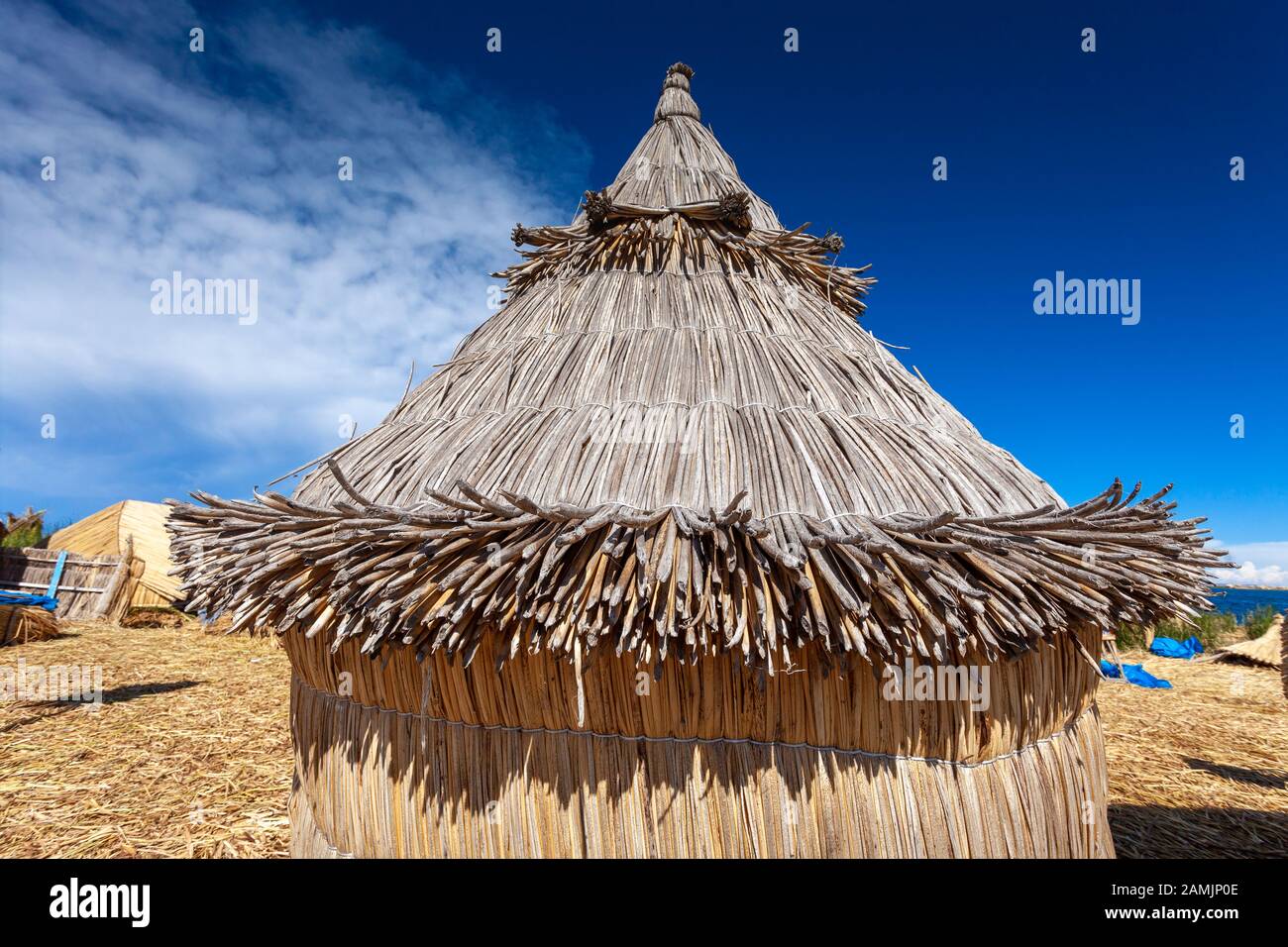 Traditional reed houses on floating Uros islands, at a distance, clouds