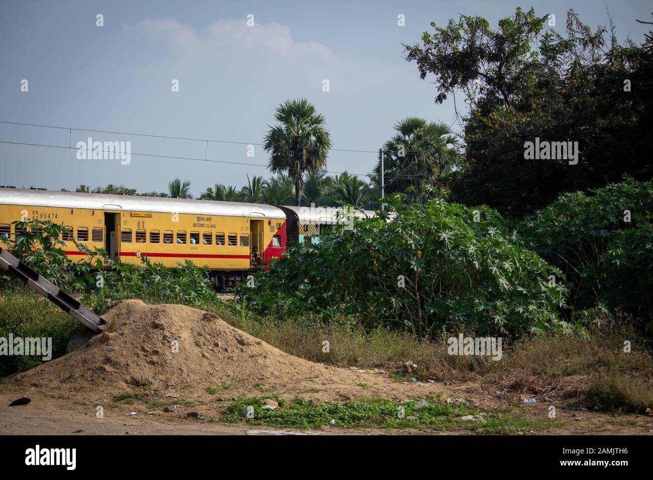 Ranipet, Tamil Nadu / India - January 04 2020: An Indian passenger train passing through a level crossing . Stock Photo