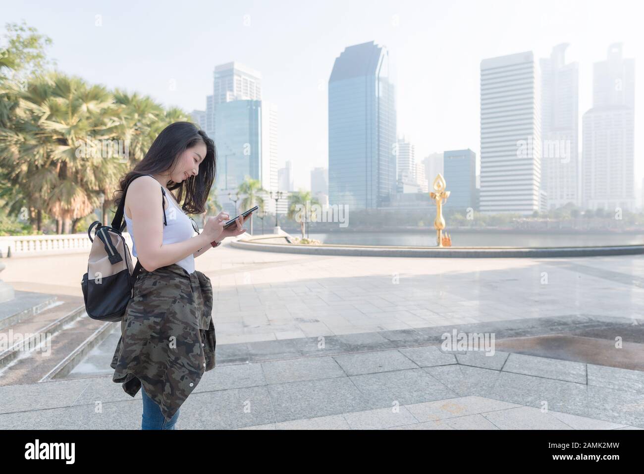 Beautiful asian tourist woman looking at mobile phone for searching location of landmark. Vacation travel in summer Stock Photo
