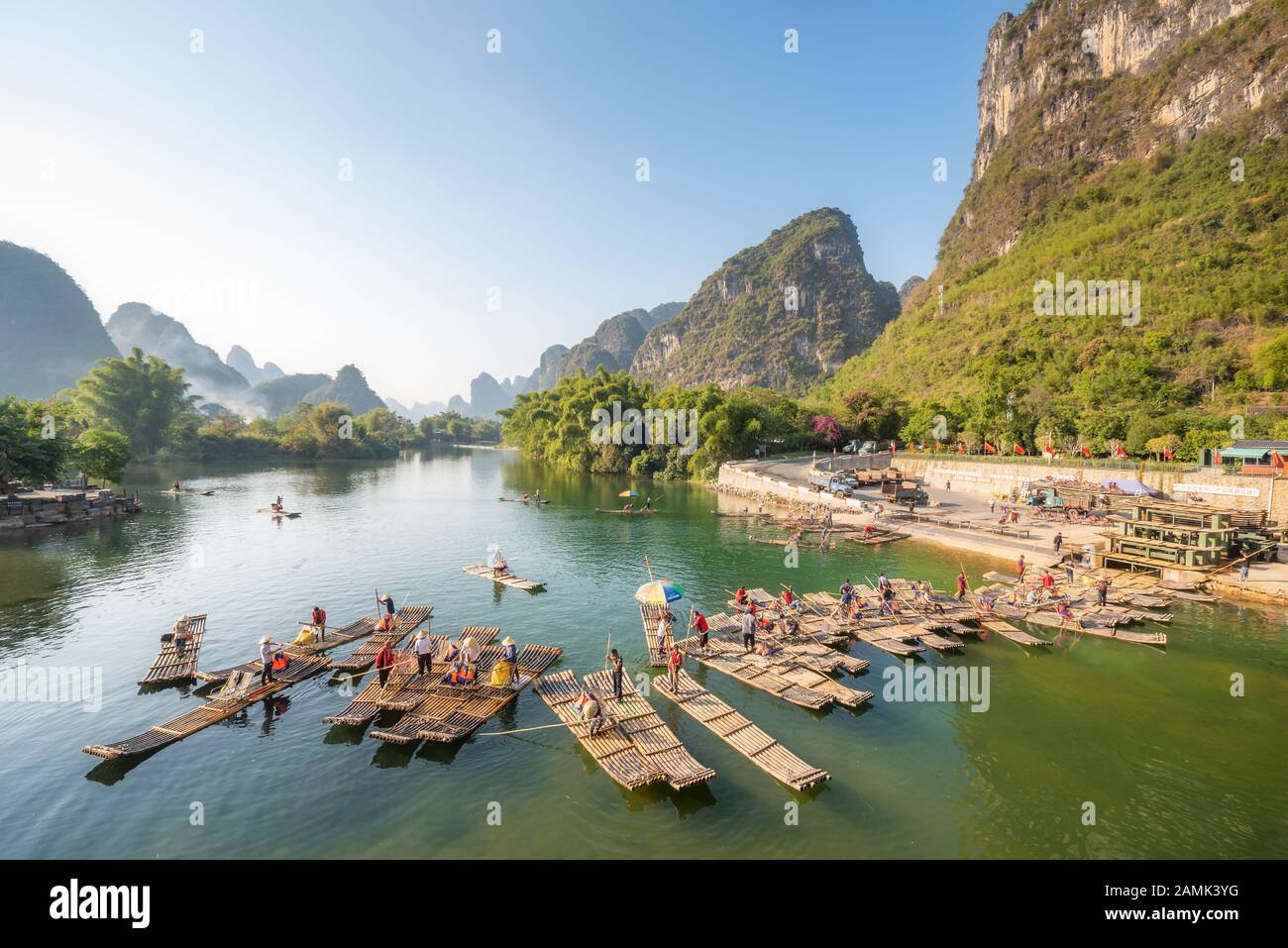 Yangshuo, Guilin, Guangxi province, China - Nov 9, 2019 : Tourist bamboo rafts arriving at the end of the tour on the river with karst limestone hills and blue sky in the background. Stock Photo