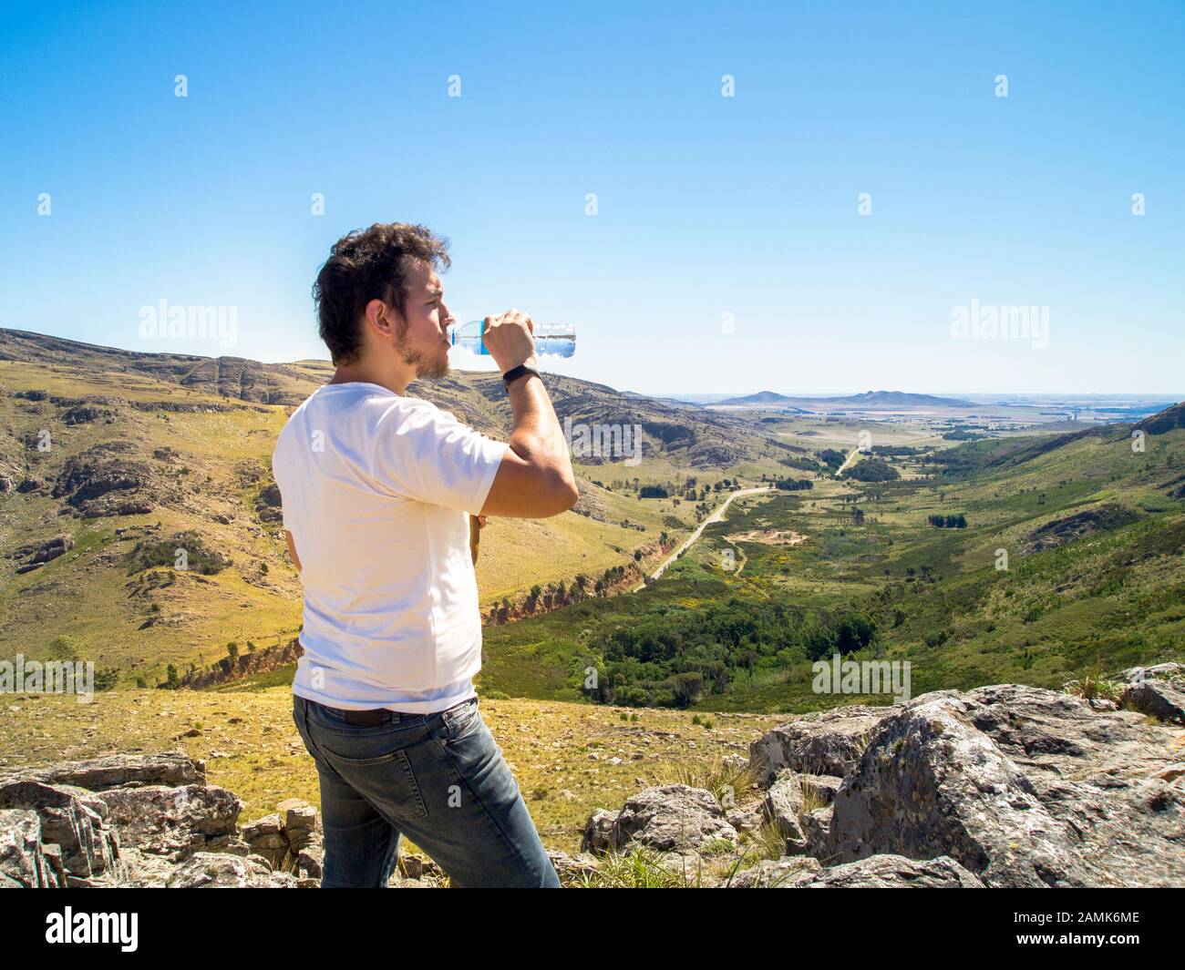 Young hiker drinking water at Cerro Bahía Blanca, Sierra de la Ventana, Buenos Aires, Argentina. Stock Photo