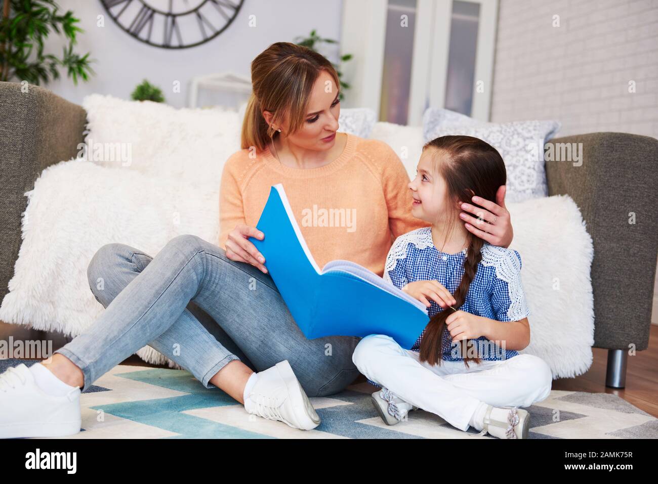 Affectionate mom helping her daughter with homework Stock Photo