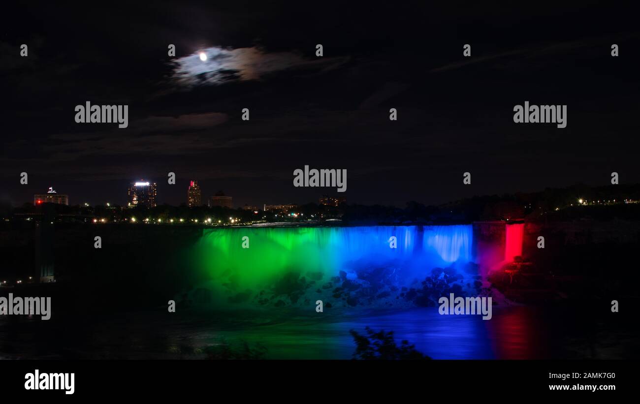 Niagara Falls illuminated in glowing colours under the moonlight Stock Photo