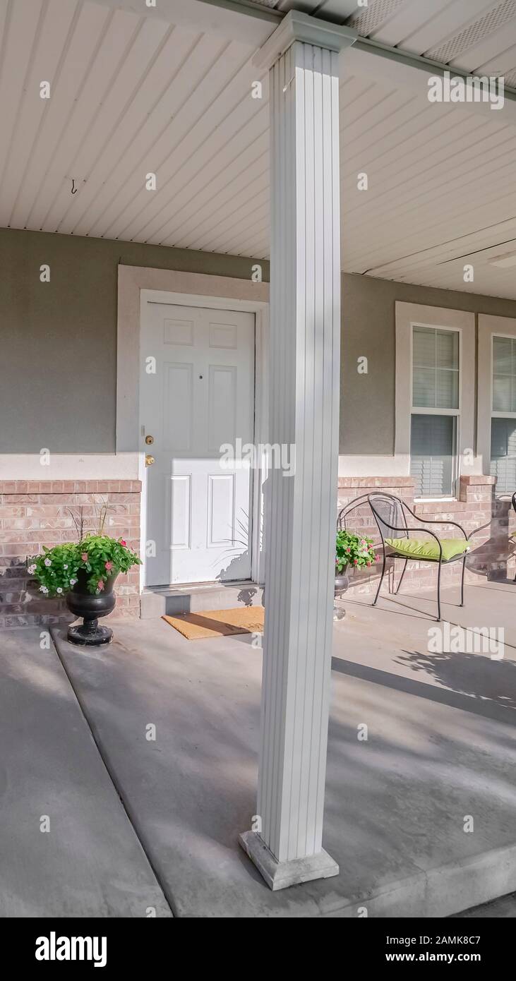 Vertical Covered veranda with chairs and front door Stock Photo - Alamy