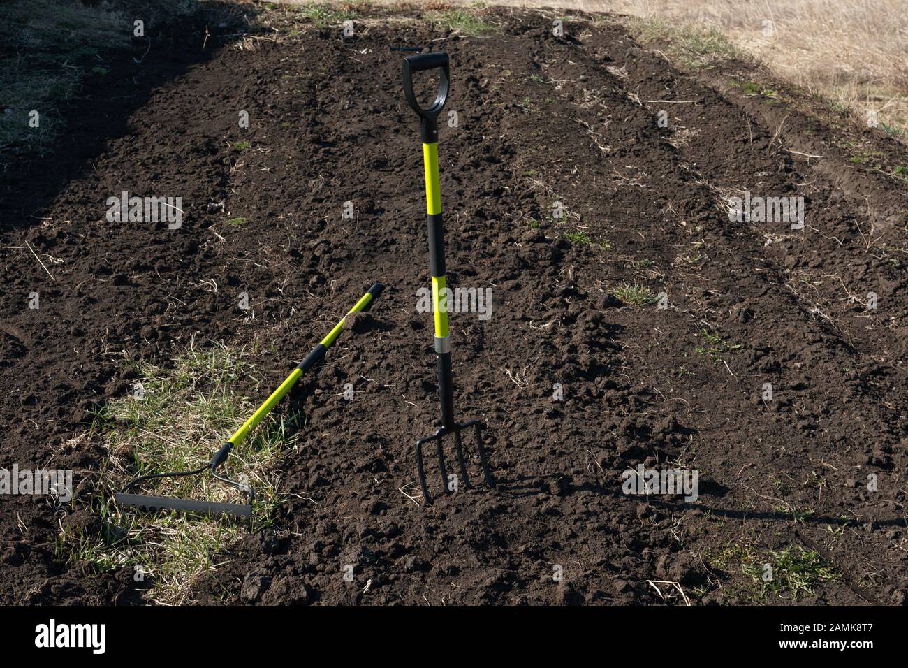 Heap of grass with tool. Cleaning in the spring garden. Stock Photo