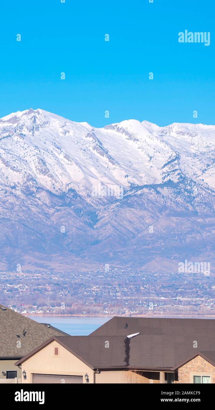 Vertical Roofs of urban houses with backdrop of snowy peaks Stock Photo ...