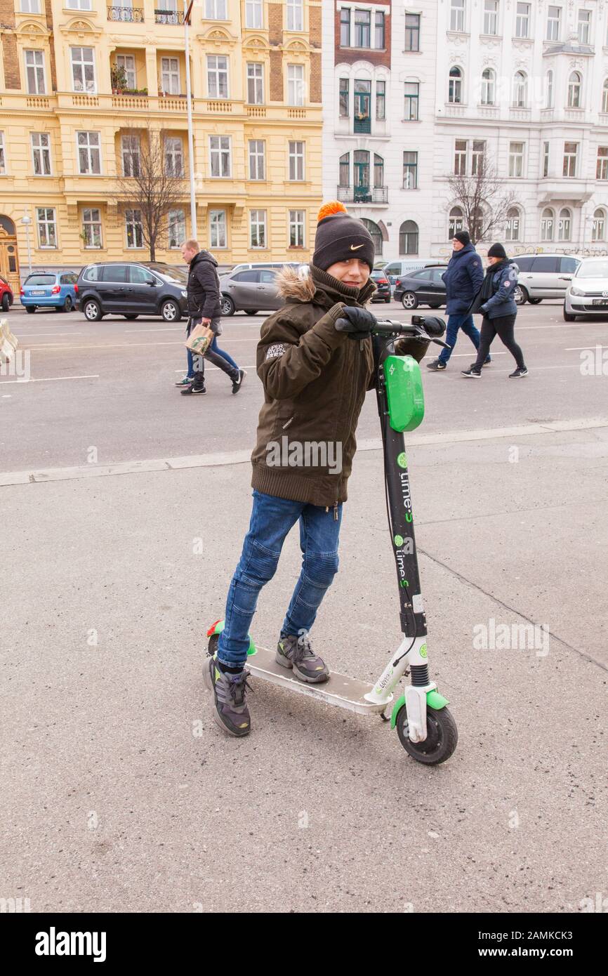 Ten year old boy riding a electric Lime hire scooter, Vienna, Austria. Stock Photo