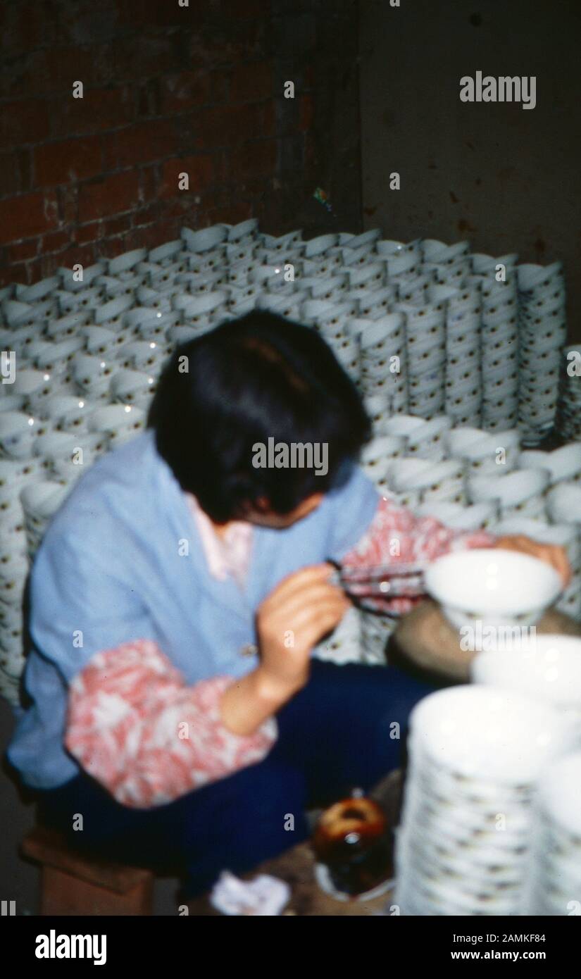 Eine Frau arbeitet als Porzellanmalerin in China, 1980er Jahre. A woman painting on porcelain, China 1980s. Stock Photo