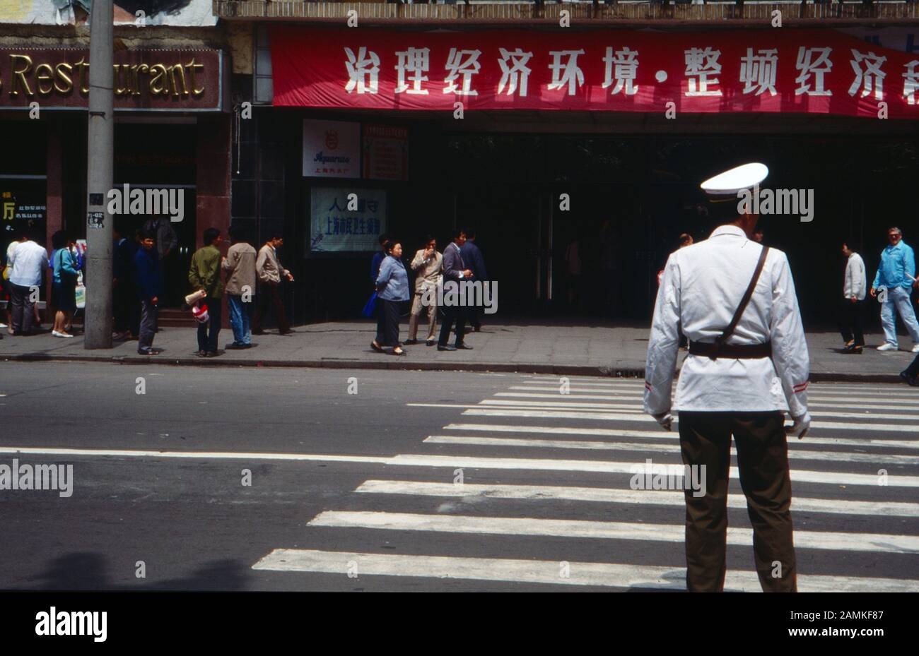 Polizist regelt den Verkehr beim Grand Theatre an der Nanking Road in Shanghai, China 1980er Jahre. Policeman near the Grand Theatre on Nanjing Road at Shanghai, China 1980s. Stock Photo